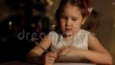 甜蜜的白种人孩子正在给房间里的圣诞老人写一封信，为圣诞节做装饰，为节日做准备
